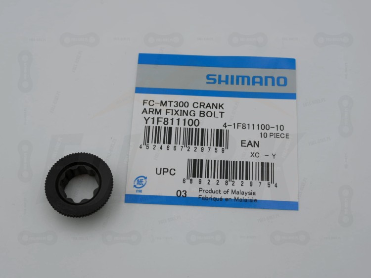 Nakrętka korby Shimano Hollowtech II na tle opakowania