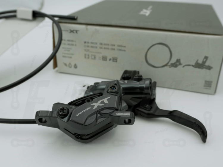 Hamulec hydrauliczny przedni tarczowy Shimano Deore XT BL-M8220 na tle opakowania