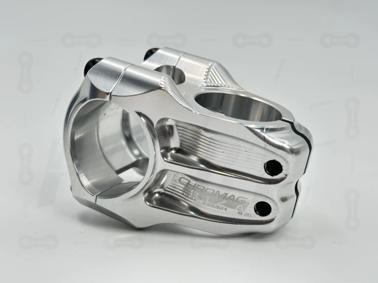 Mostek Chromag Riza 31.8 mm w kolorze srebrnym. Zbliżenie na moty graficzny oraz śruby boczne mocujące do sterówki.