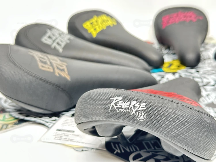 Siodełka do skaknia jibbowania slopeduro Reverse Nico Vink Shovel &amp; Shred w kolorze zółtym, różowym, białym, niebieskim, pomarańczowym, szarym, czerwonym, złotym, brązowym, białym.