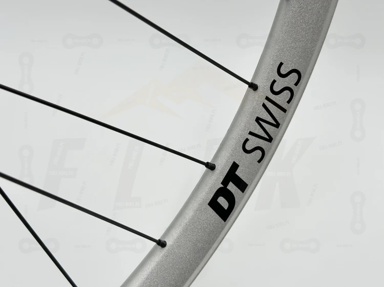 Srebrne koło Dt Swiss FR571 z piastą tanke th490 w rozmiarze 27,5 z czarnymi szprychami dt swiss champion. Zbliżenie na czarny napis dt swiss