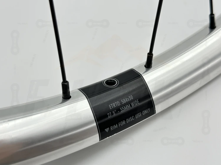 Koło Tylne Reverse Black One 27,5" 148x12 Single speed srebrne z srebrną piastą dartmoor reel expert boost single speed. Zbliżenie na srebrny napis reverse oraz logo producenta.