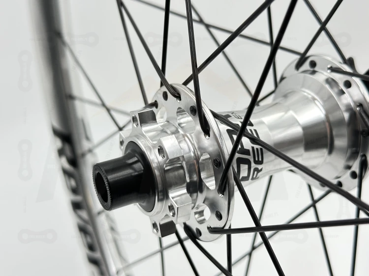 Koło Tylne Reverse Black One 27,5" 148x12 Single speed srebrne z srebrną piastą dartmoor reel expert boost single speed. Zbliżenie na srebrną piastę z czarnym napisem dartmoor