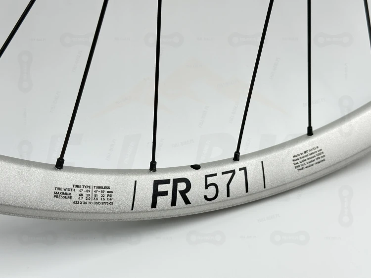 Zbliżenie na srebrną obręcz DT Swiss Fr571 29" i czarny napis FR571