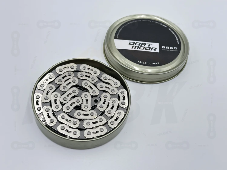 Łańcuch single speed Dartmoor CORE główne zdjęcie przedstawia widok łańcucha w opakowaniu oraz widok na markę producenta w kolorze srebrnym